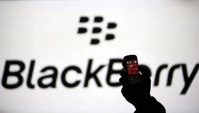 Man is silhouetted against a video screen with Blackberry logo as he pose with Blackberry Q10 in this photo illustration taken in the central Bosnian town of Zenica