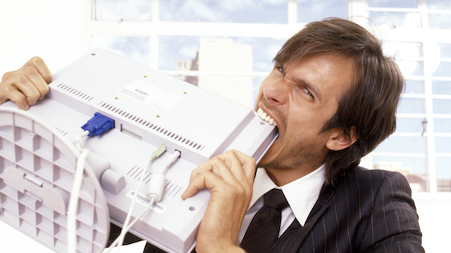 Businessman biting a computer monitor